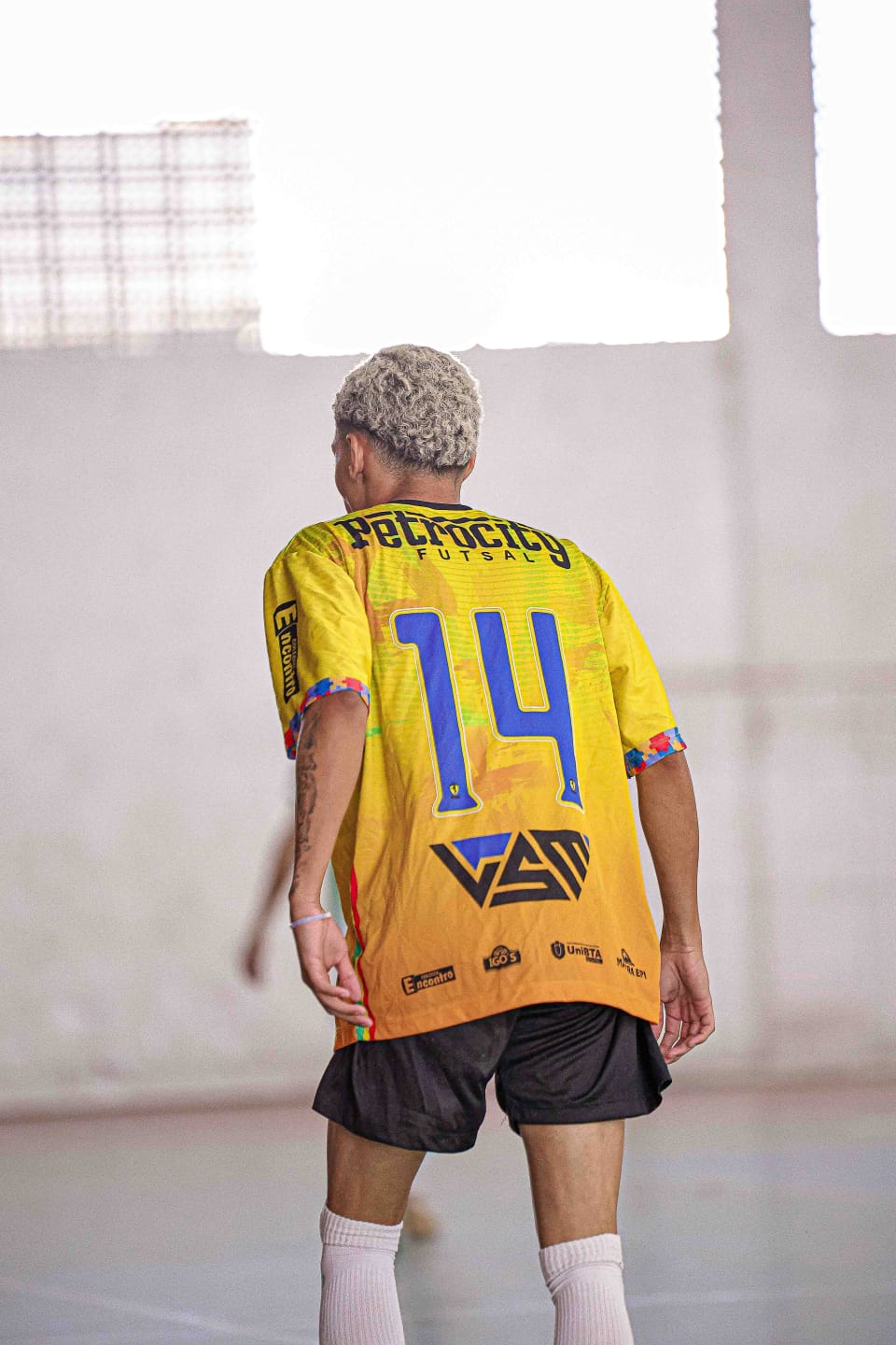 Detalhe das costas do uniforme amarelo do Sub-18 com a identificação Petrocity Futsal